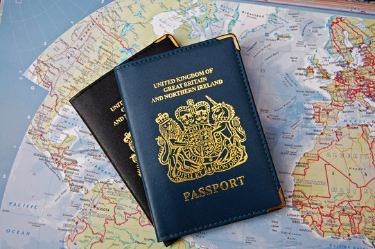 Two British passports overlapping on a map of the world implying travel around the world