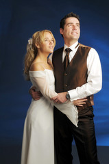 Portrait of the young happy newlyweds on dark background