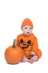 Adorable baby boy in pumpkin outfit with a pumpkin