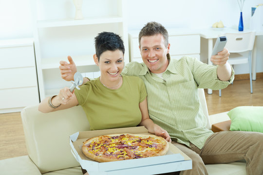 Happy couple eating pizza