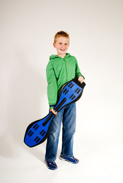 handsome young boy standing holding waveboard