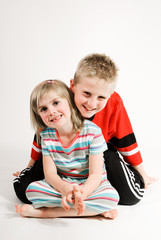 a brother and sister kneeling close together