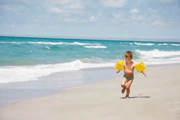 Fototapeta na wymiar young boy running on beach