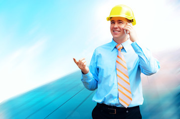 Young architect wearing a protective helmet standing on the buil