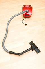 Vacuum cleaner on the wooden floor