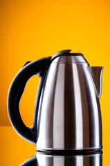 Shiny kettle against the colorful gradient background