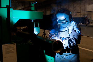 worker weld metal in factory and spark