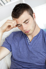 Tired caucasian man sitting on the sofa