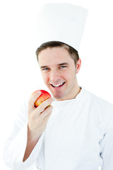 Happy male cook holding  red apple smiling at the camera