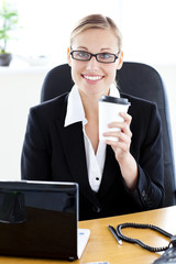 Delighted caucasian businesswoman holding a coffee smiling at th