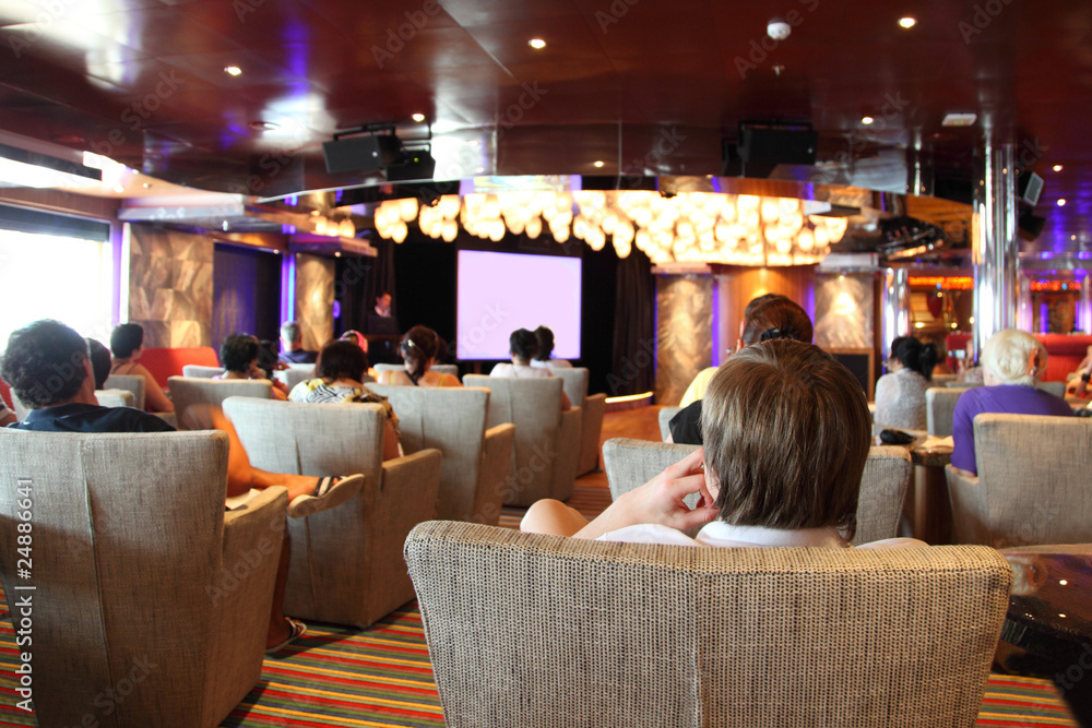 Wall mural group of people at cruise liner cinema looking at screen