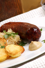 geräucherte Wurst mit Sauerkraut und Röstkartoffeln