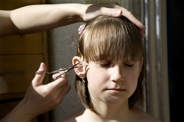 little girl and hand of mother - hairdresser