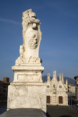 Fototapeta na wymiar Pisa - lion on the waterfront and gothic chapel