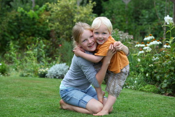 Fototapeta premium Kleiner Junge und Mädchen spielen im Garten