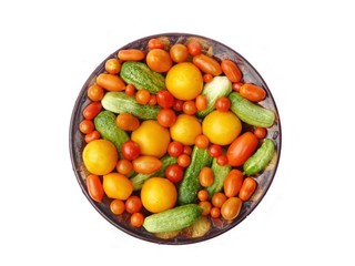 Fresh tomatoes and cucumbers on a plate. Insulation.