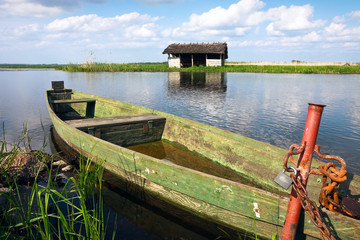 Old boat secured with a padlock at the lake