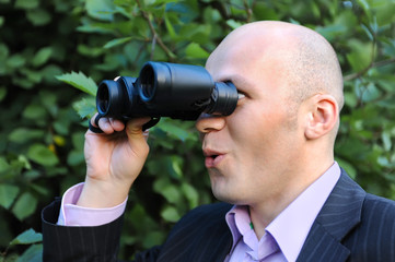 Businessman looking through binoculars