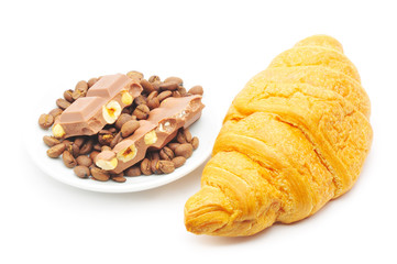 croissant and a plate with coffe beans and chocolate
