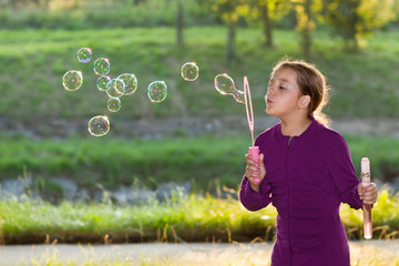 Little girl blowing soap bubbles