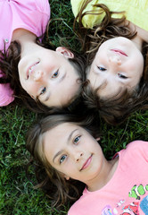 3 têtes d'enfants dans l'herbe