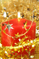 Kerze zwischen goldenen Sternchen