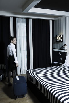 Woman arriving in a hotel bedroom