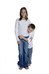 Young boy and girl hugging, studio shot isolated on white