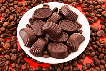 Chocolate and coffee beans on red background