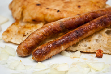 two beed sausages on flatbread with onion