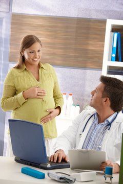 Pregnant woman smiling at doctor.