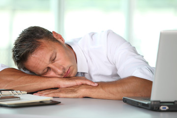 Fototapeta premium Businessman asleep on his desk