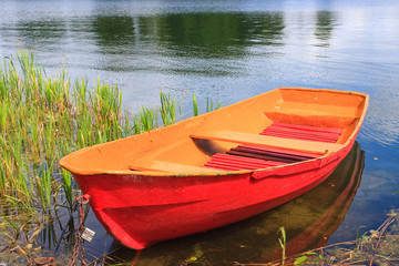 Red rowing boat on lake