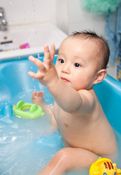 Small baby boy is taking a bath