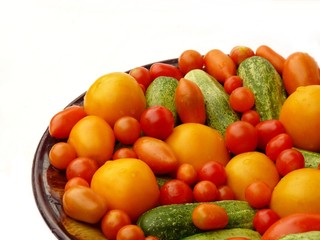 Fresh tomatoes and cucumbers on a plate. Insulation.