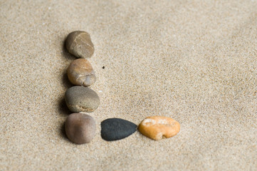 Fototapeta na wymiar lettre L en galets zen dans le sable