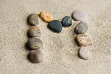 Fototapeta na wymiar Litera M Zen kamienie na piasku