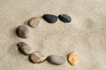 Fototapeta na wymiar lettre C en galets zen dans le sable
