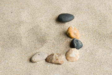 Fototapeta na wymiar lettre J en galets zen dans le sable