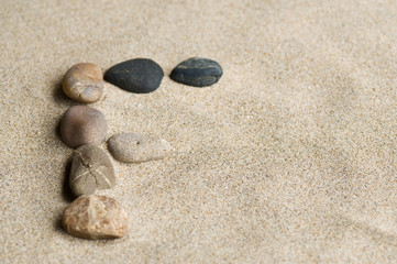 Fototapeta na wymiar lettre F en galets zen dans le sable