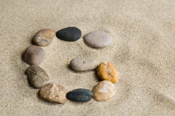 Fototapeta na wymiar lettre G en galets zen dans le sable
