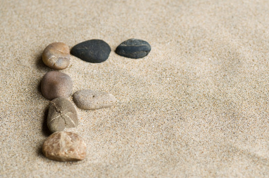 lettre F en galets zen dans le sable