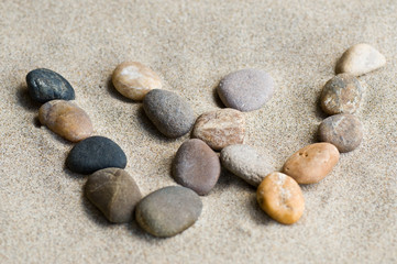 Fototapeta na wymiar Litera W zen kamienie na piasku
