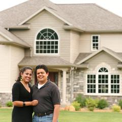 Happy couple in front of a house portrait