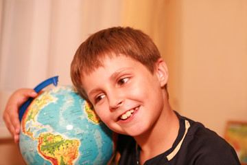 boy embracing globe of world