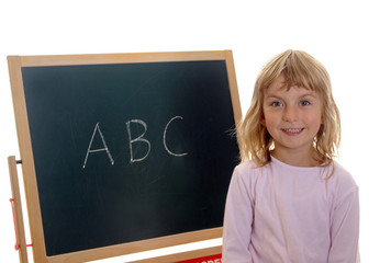 Kleines Mädchen vor Tafel mit ABC