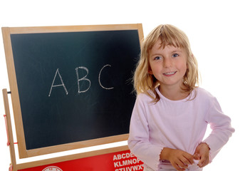 Kleines Mädchen vor Tafel mit ABC