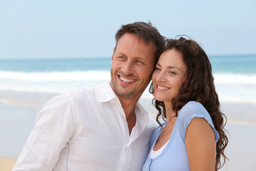 Obraz premium Smiling couple on vacation at the beach