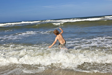 child has fun in the waves