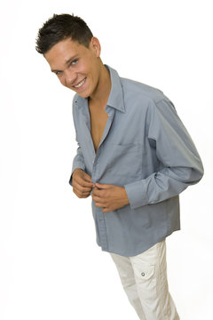 Jeune homme boutonnant sa chemise
